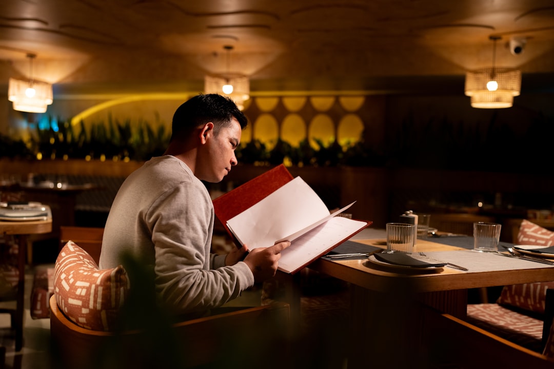 Man reading a menu at a restaurant table
